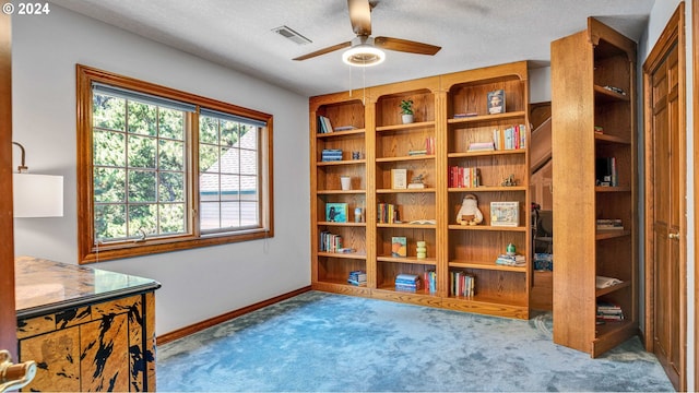 interior space with a textured ceiling, ceiling fan, and light carpet