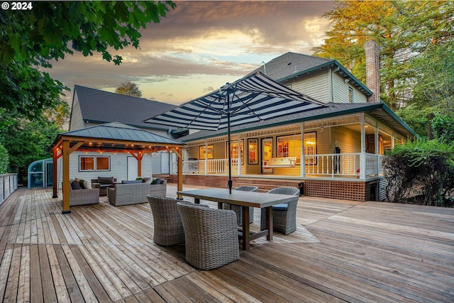 deck at dusk featuring a gazebo and outdoor lounge area