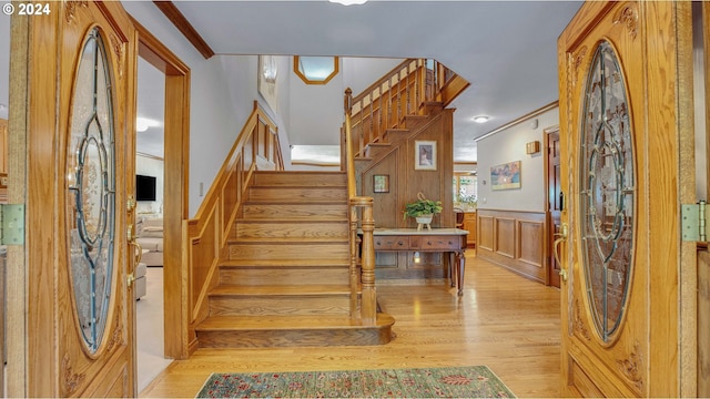 entrance foyer with light hardwood / wood-style floors and crown molding