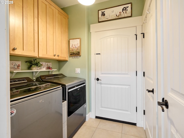 laundry room with separate washer and dryer, cabinets, and light tile patterned floors