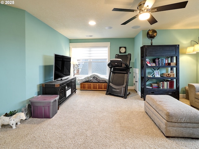 living room with a textured ceiling, light carpet, and ceiling fan