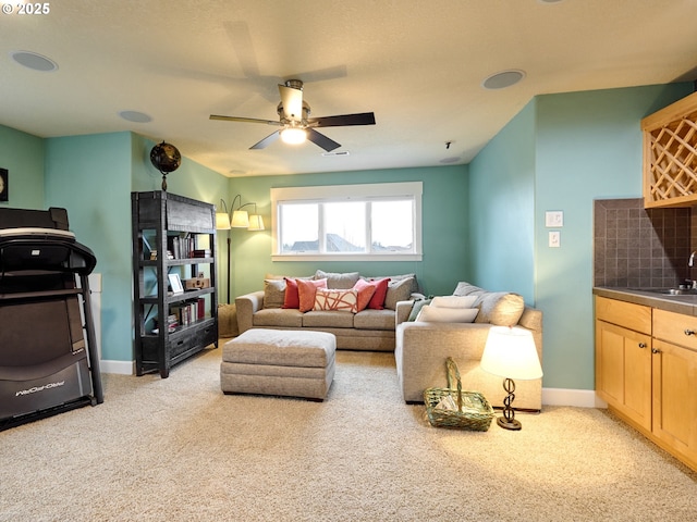 carpeted living room with indoor wet bar and ceiling fan