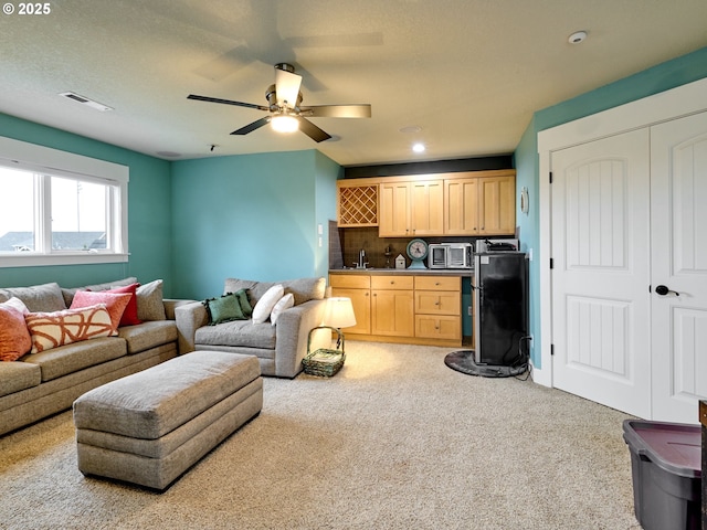 carpeted living room featuring sink and ceiling fan