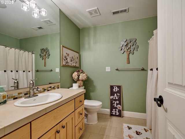 bathroom featuring toilet, vanity, tile patterned floors, and decorative backsplash