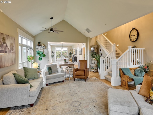 living room with high vaulted ceiling, hardwood / wood-style floors, and ceiling fan