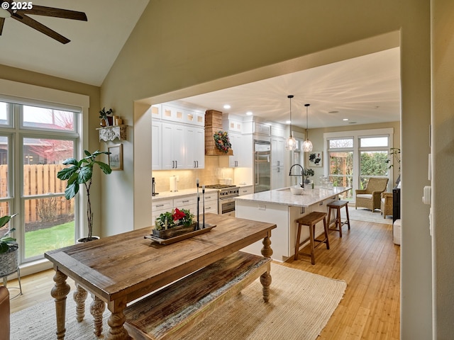 dining space featuring a healthy amount of sunlight, ceiling fan, light hardwood / wood-style flooring, and sink