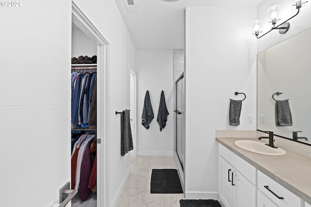 bathroom with vanity and a shower with shower door