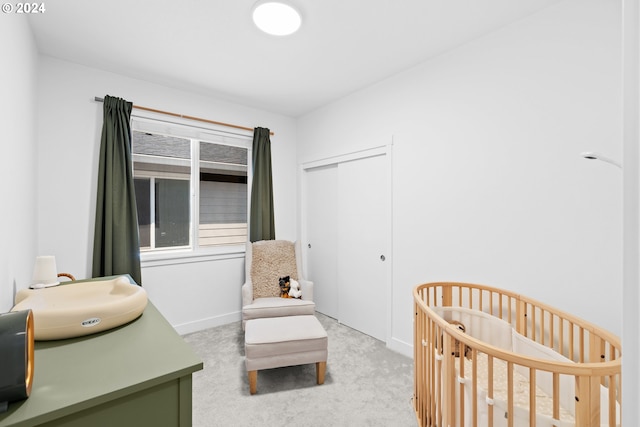 carpeted bedroom featuring a closet, a nursery area, and sink