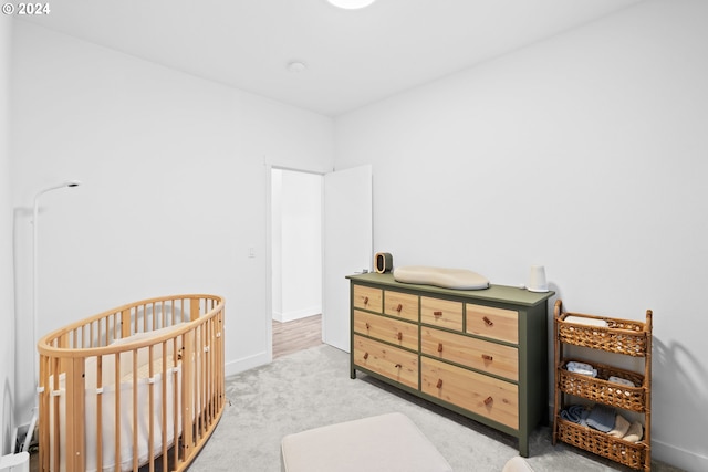 carpeted bedroom featuring a nursery area