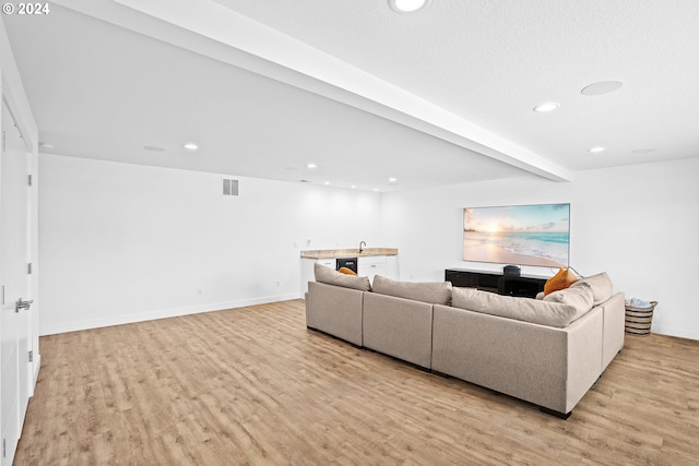 living room with light hardwood / wood-style floors and beam ceiling