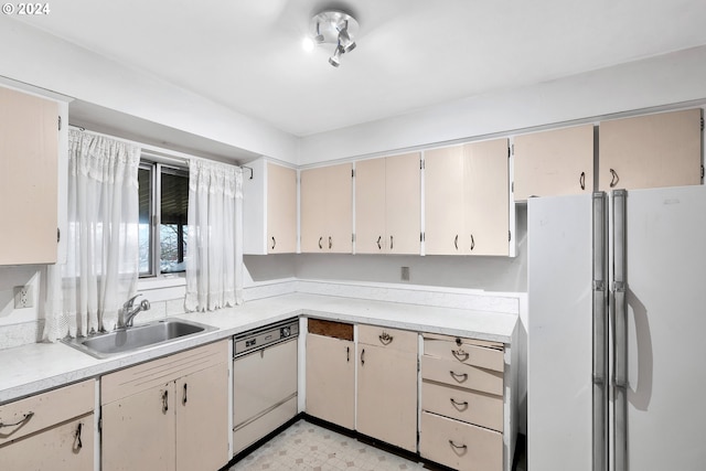 kitchen with cream cabinets, white appliances, and sink