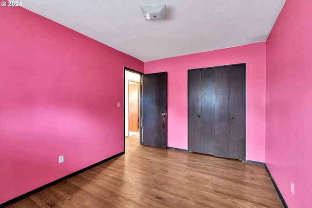 unfurnished bedroom with a closet and light hardwood / wood-style flooring