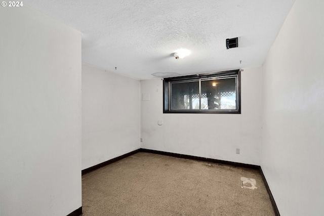 carpeted spare room with a textured ceiling