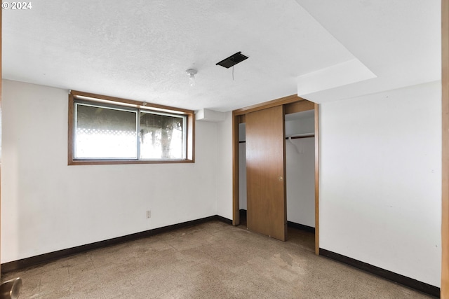 unfurnished bedroom featuring a textured ceiling and a closet