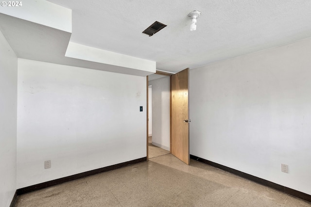 unfurnished room with a textured ceiling