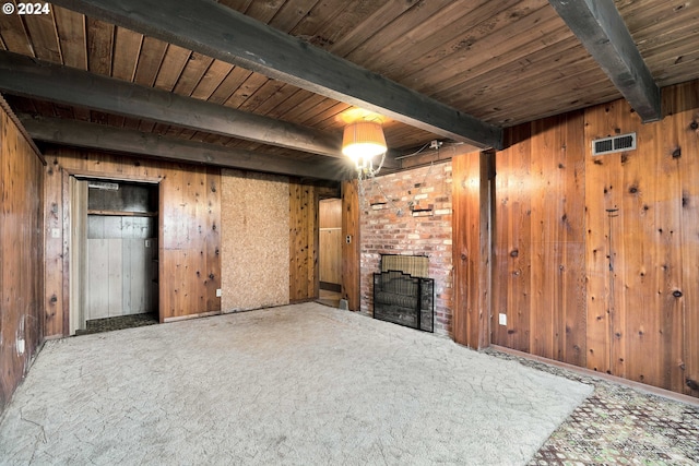 unfurnished living room with beam ceiling, carpet flooring, wooden walls, a fireplace, and wood ceiling