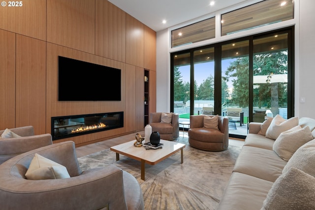 living room with a towering ceiling, a fireplace, and floor to ceiling windows