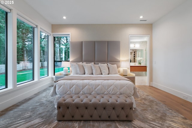 bedroom featuring hardwood / wood-style floors and ensuite bath