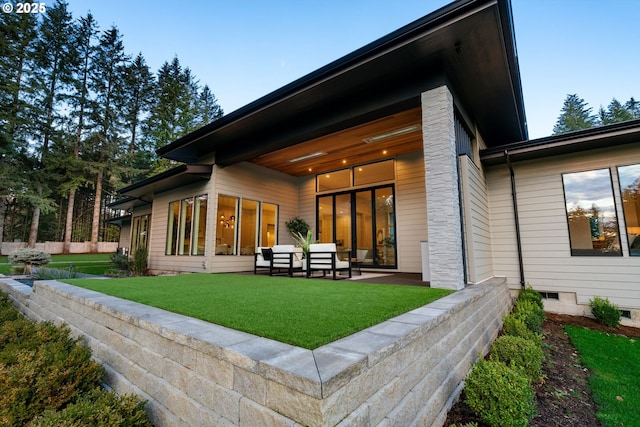 rear view of house featuring an outdoor hangout area, a patio area, and a lawn