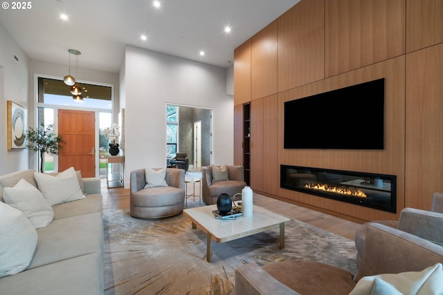 living room featuring light hardwood / wood-style flooring and a high ceiling