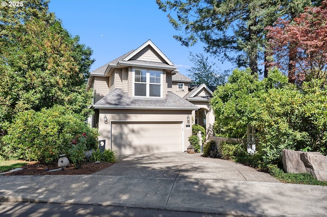 traditional home with concrete driveway, an attached garage, roof with shingles, and stucco siding