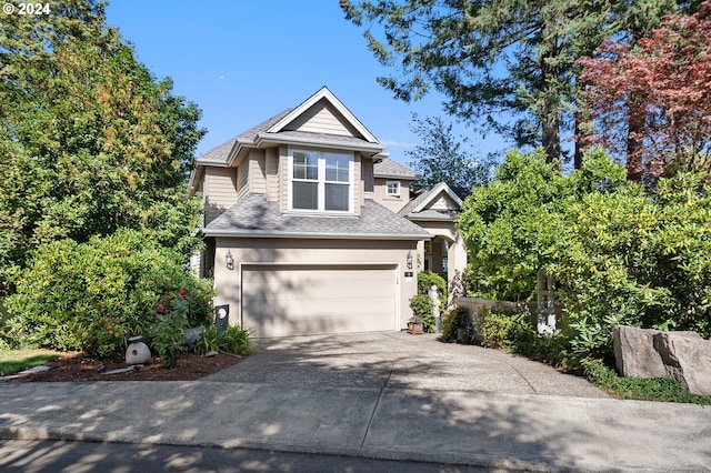 view of front of property with a garage, a shingled roof, driveway, and stucco siding