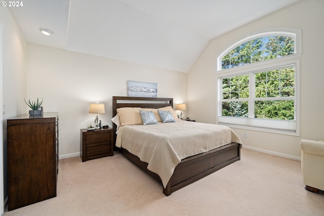 bedroom featuring lofted ceiling, baseboards, and light colored carpet