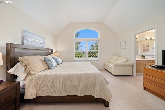 bedroom featuring lofted ceiling, connected bathroom, and light colored carpet