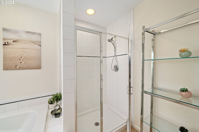 bathroom with a bath and a shower stall