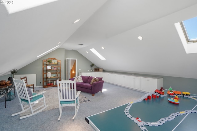 playroom with light colored carpet and vaulted ceiling with skylight