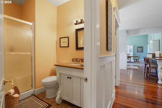 bathroom featuring walk in shower, vanity, toilet, and hardwood / wood-style floors