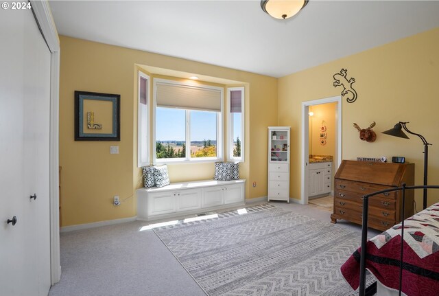 carpeted bedroom featuring ensuite bath and a closet