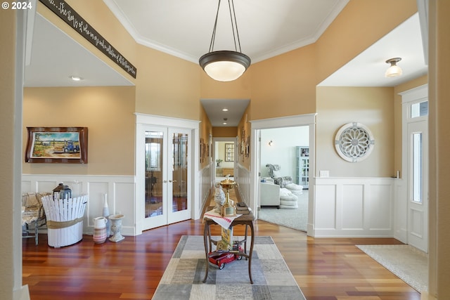 entrance foyer with crown molding, hardwood / wood-style floors, and french doors