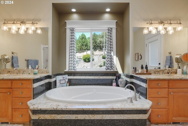 bathroom with vanity and a relaxing tiled tub