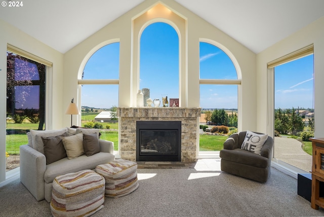 living room featuring lofted ceiling, a fireplace, and carpet