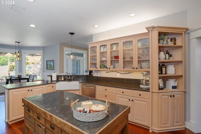 kitchen with sink, hanging light fixtures, a center island, kitchen peninsula, and dark wood-type flooring