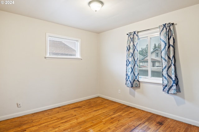 unfurnished room featuring a healthy amount of sunlight and hardwood / wood-style floors