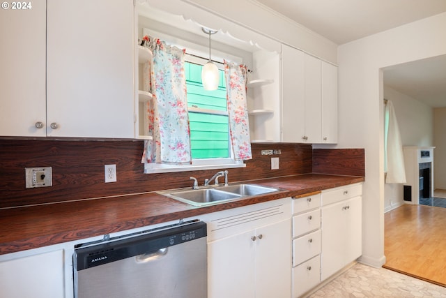 kitchen featuring dishwasher, white cabinetry, sink, butcher block countertops, and pendant lighting