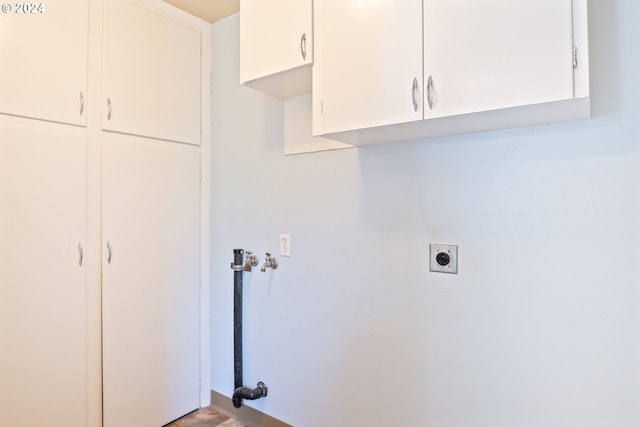 laundry room with hookup for an electric dryer and cabinets