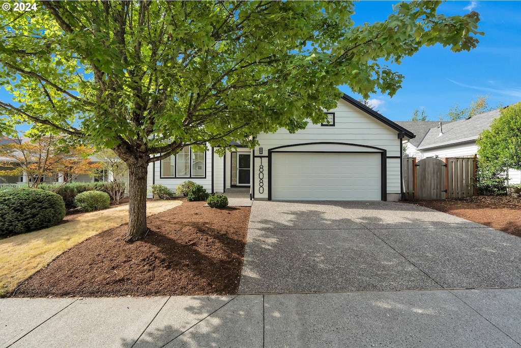 view of property hidden behind natural elements featuring a garage