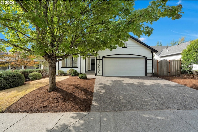 view of property hidden behind natural elements featuring a garage