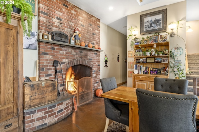 dining room with a fireplace and concrete floors