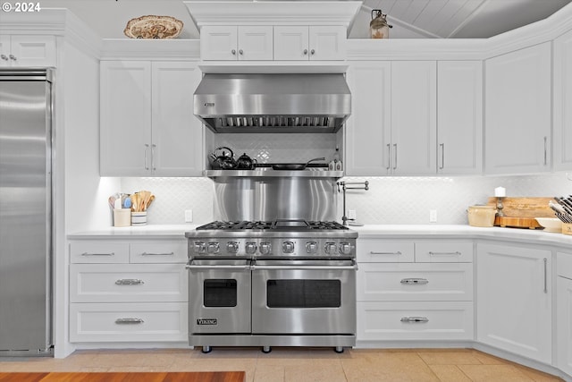 kitchen featuring high end appliances, white cabinets, backsplash, and ventilation hood