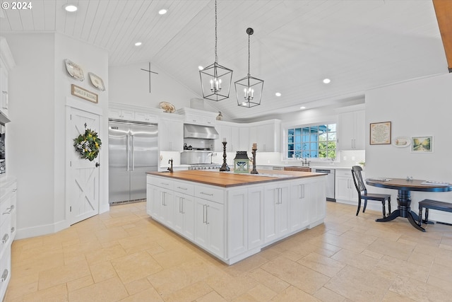 kitchen featuring a center island with sink, butcher block counters, white cabinetry, appliances with stainless steel finishes, and ventilation hood