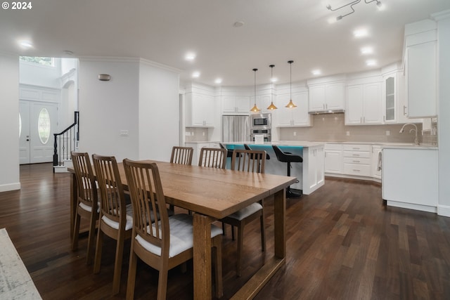 dining space featuring sink, dark hardwood / wood-style flooring, and ornamental molding