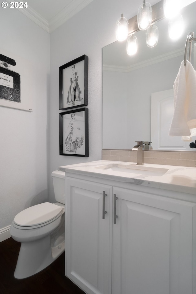 bathroom featuring vanity, toilet, ornamental molding, and wood-type flooring