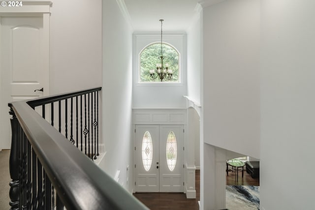 entrance foyer featuring dark hardwood / wood-style floors, a chandelier, and crown molding