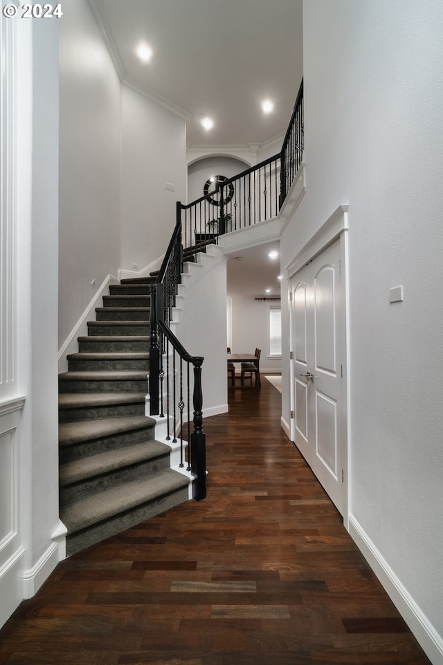 stairway featuring crown molding and hardwood / wood-style flooring