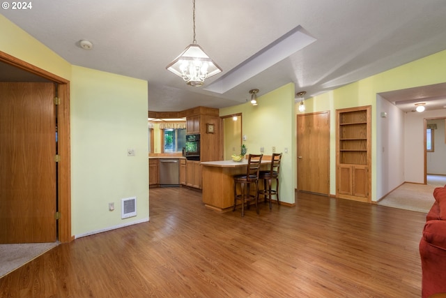 kitchen with open floor plan, wood finished floors, black oven, dishwasher, and a peninsula