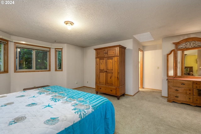 bedroom with light carpet, a textured ceiling, and baseboards